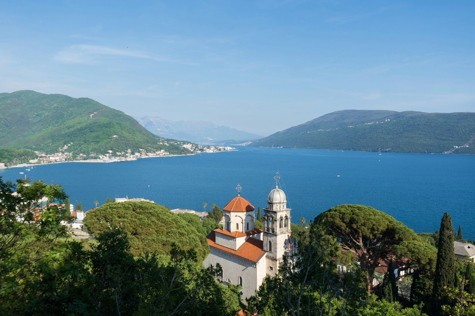 Budva staat bekend om haar stranden, oude stad en levendige sfeer. Minder bekend is dat het ook een uitstekende locatie is voor boot huren in Montenegro. Vanuit Budva vaar je langs een van de mooiste stukken kust van het land. Onderweg kom je langs Sveti Nikola, verborgen zwembaaien en het beroemde eiland Sveti Stefan. Vooral in de ochtenduren is het uitzicht vanaf het water indrukwekkend. De kustlijn is hier opener dan in de Baai van Kotor. Daardoor voelt het varen avontuurlijker aan. Tegelijkertijd zijn de afstanden overzichtelijk, waardoor ook minder ervaren schippers prima uit de voeten kunnen. Na een dag op het water wandel je zo de gezellige oude binnenstad van Budva in voor een drankje of een diner aan zee. Die combinatie maakt Budva bijzonder aantrekkelijk voor een ontspannen vakantie. 5. Bar: rustig varen buiten de drukte: Herceg novi